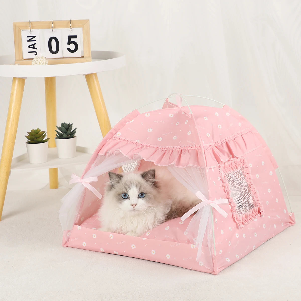 Pink floral cat tent bed with ruffle trim and a Ragdoll cat resting inside