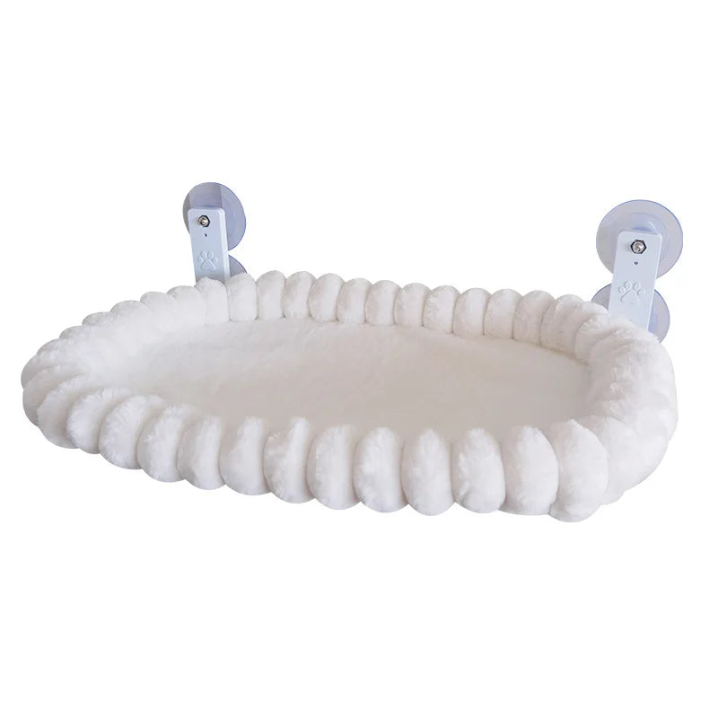 Angled studio view of the white plush cat window hammock showing its pom-pom edge and two suction cup support arms