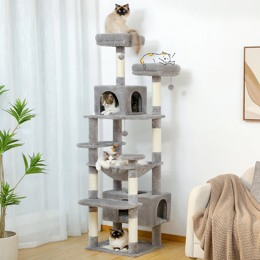 Light gray tall cat tree tower with condos, a hammock and sisal scratching posts in a bright living room with four cats