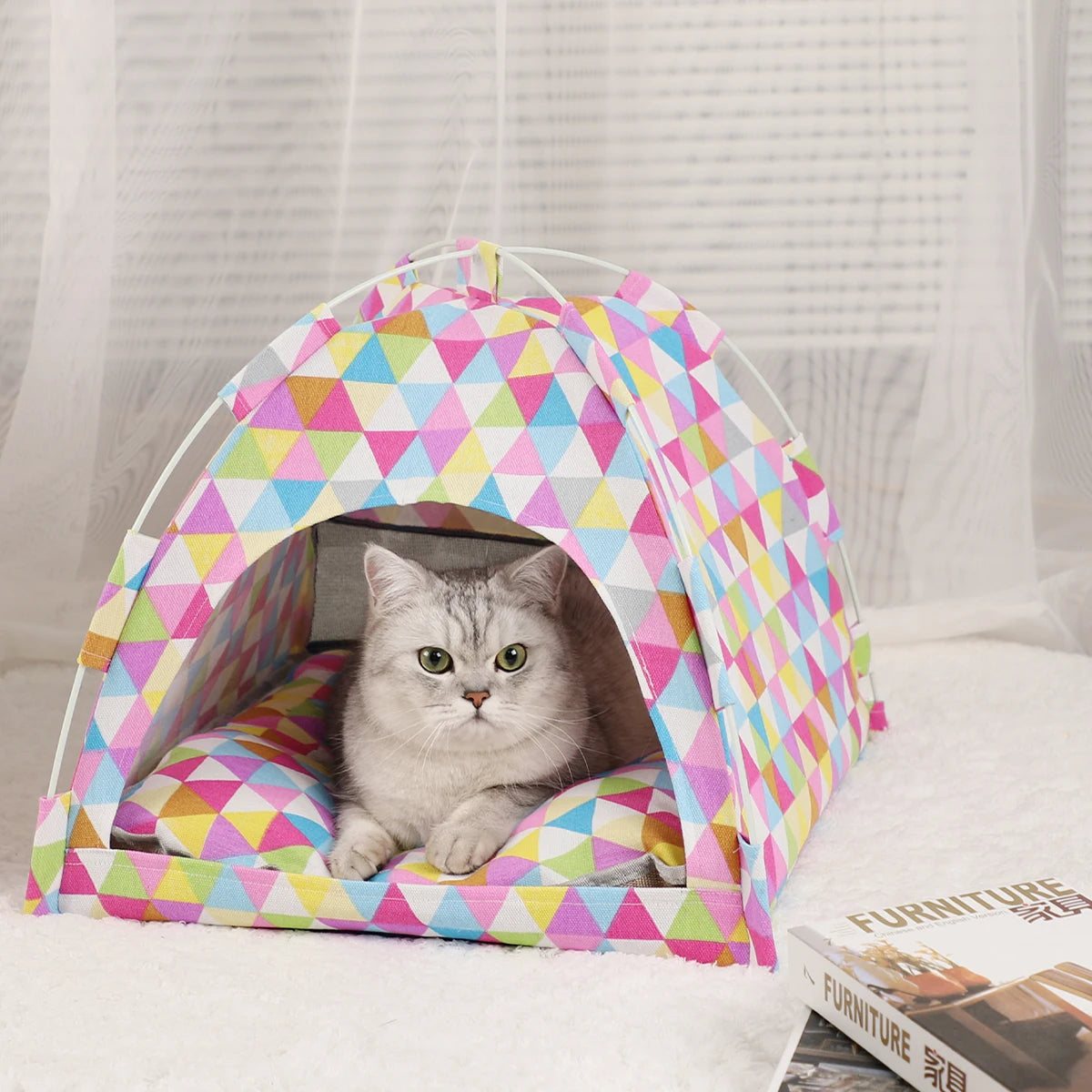 Colourful triangle print cat tent bed with a tabby cat resting inside