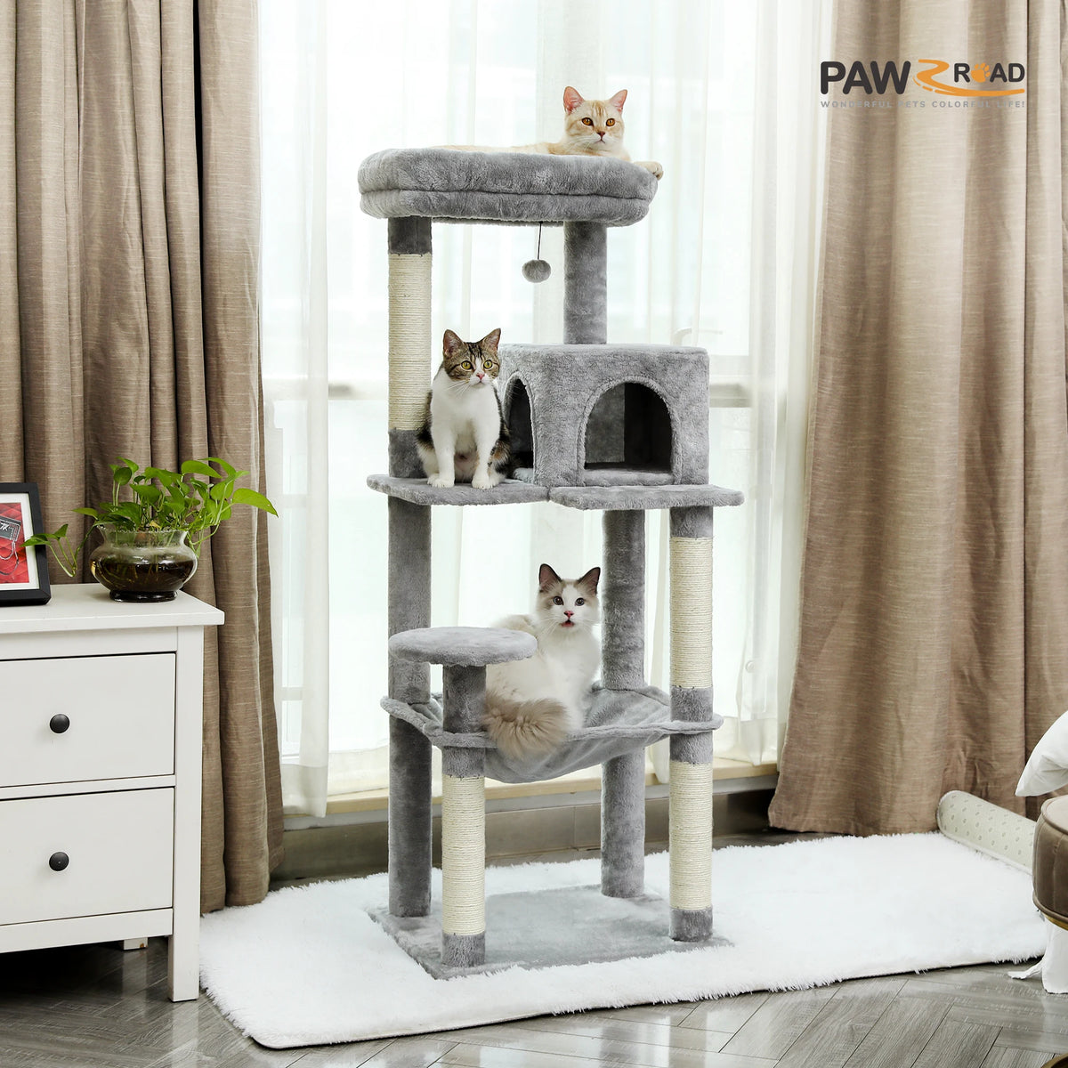 Grey PAWZ Road cat tree beside a living room window with three cats on its platforms