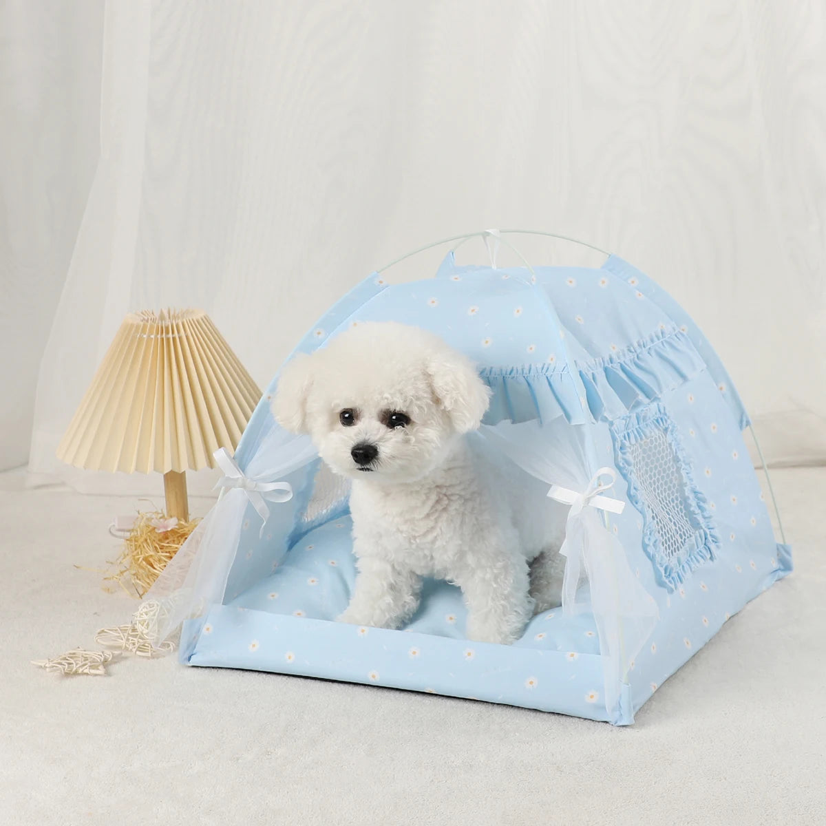 Light blue floral pet tent bed with a small white dog sitting inside
