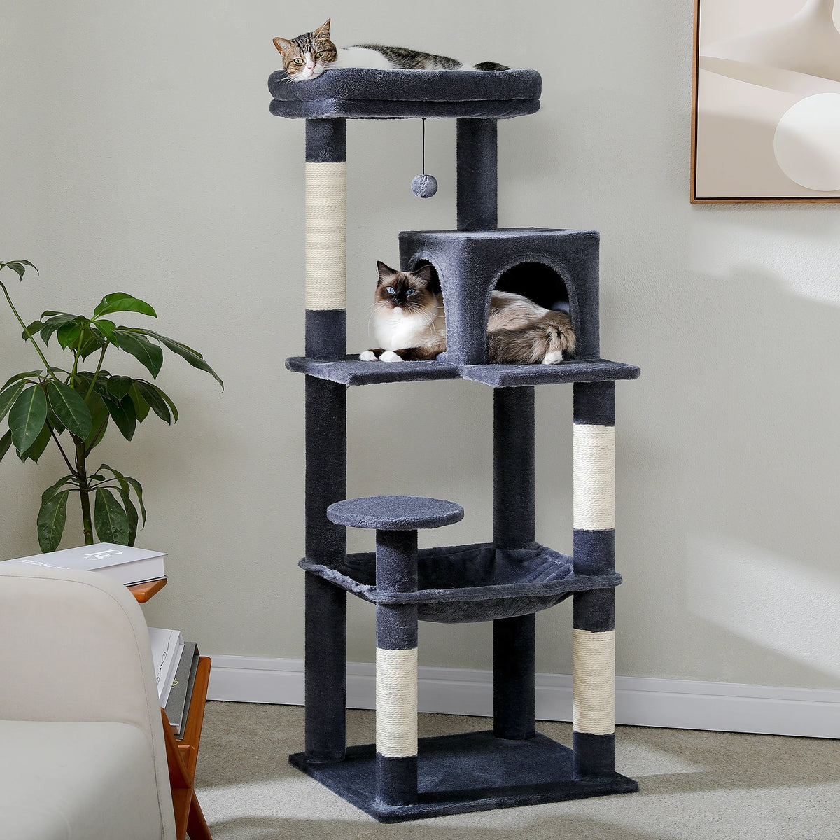 Dark grey cat tree in a living room with two cats in the condo and one on the top perch