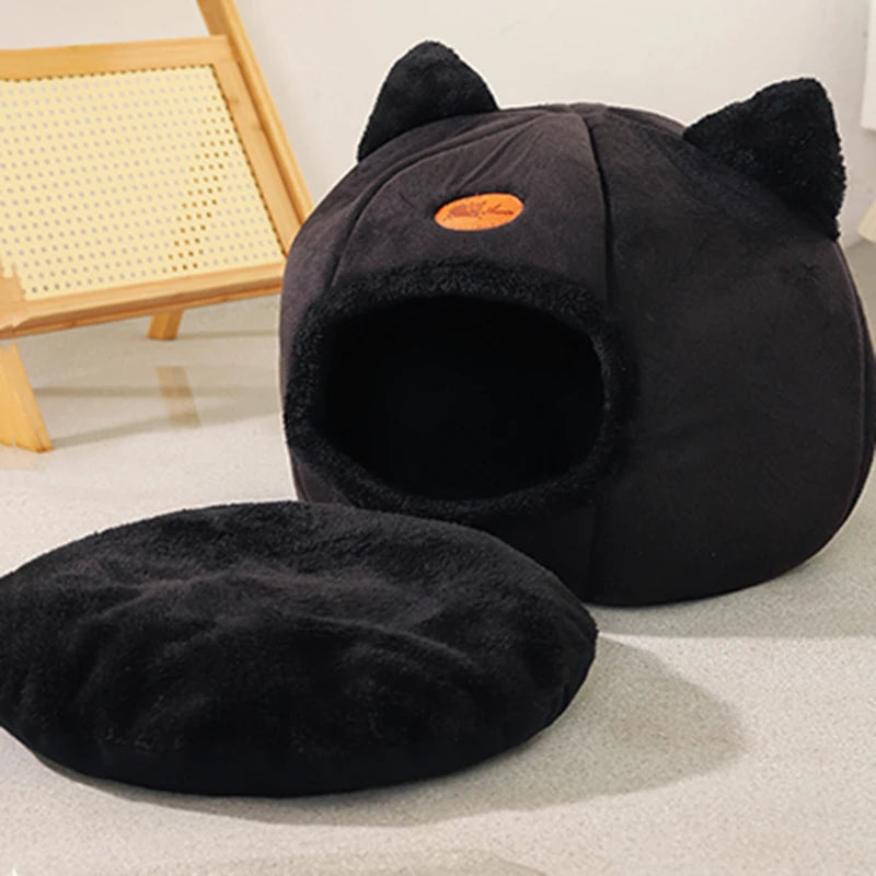 Black cat cave bed with its round cushion removed and placed beside it