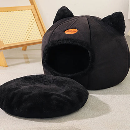 Black cat cave bed with its round cushion removed and placed beside it