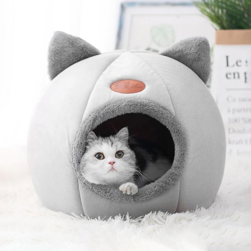 Light grey cat cave bed with cat ears and a cat looking out from inside