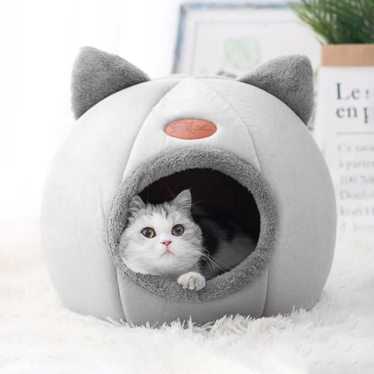 Light grey cat cave bed with cat ears and a cat looking out from inside