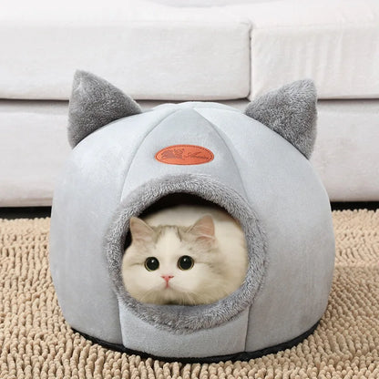 Cat resting inside a light grey enclosed cat cave bed on a beige carpet
