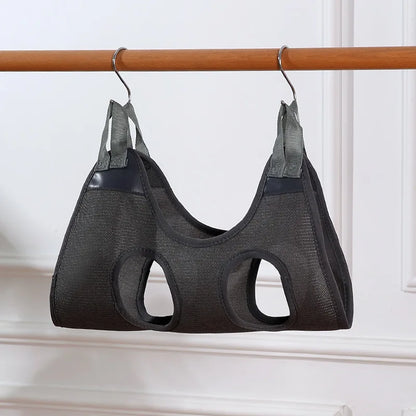 Dark gray mesh cat grooming hammock hanging from a wooden rail on two S-hooks