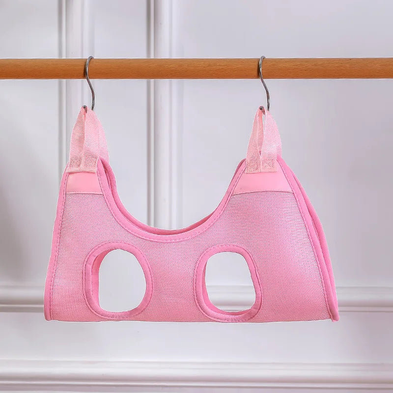 Pink mesh cat grooming hammock hanging from a wooden rail on two S-hooks