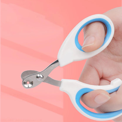 Hand holding blue cat nail clippers, showing the round cutting hole in the steel blade