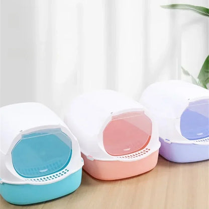 Three covered cat litter boxes in blue, pink and purple with hoods and swing door flaps