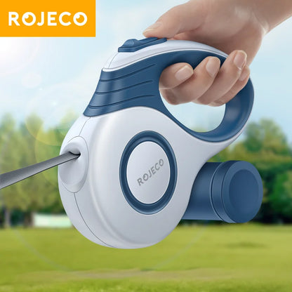 Hand holding the blue ROJECO retractable dog leash outdoors, close-up of the housing and handle
