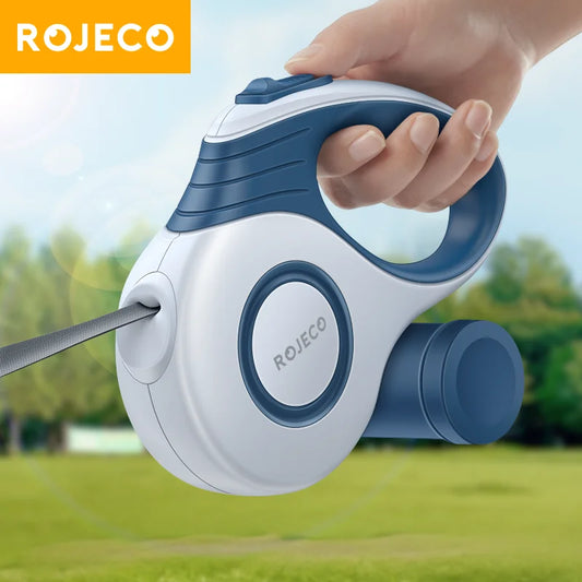 Hand holding the blue ROJECO retractable dog leash outdoors, close-up of the housing and handle